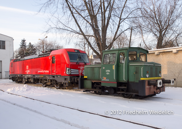 Die Werkslok schleppt den feierlich übergebenen Siemens Vectron mit fröhlichem Pfeifen aus der Werkshalle des Eisenbahninstituts
